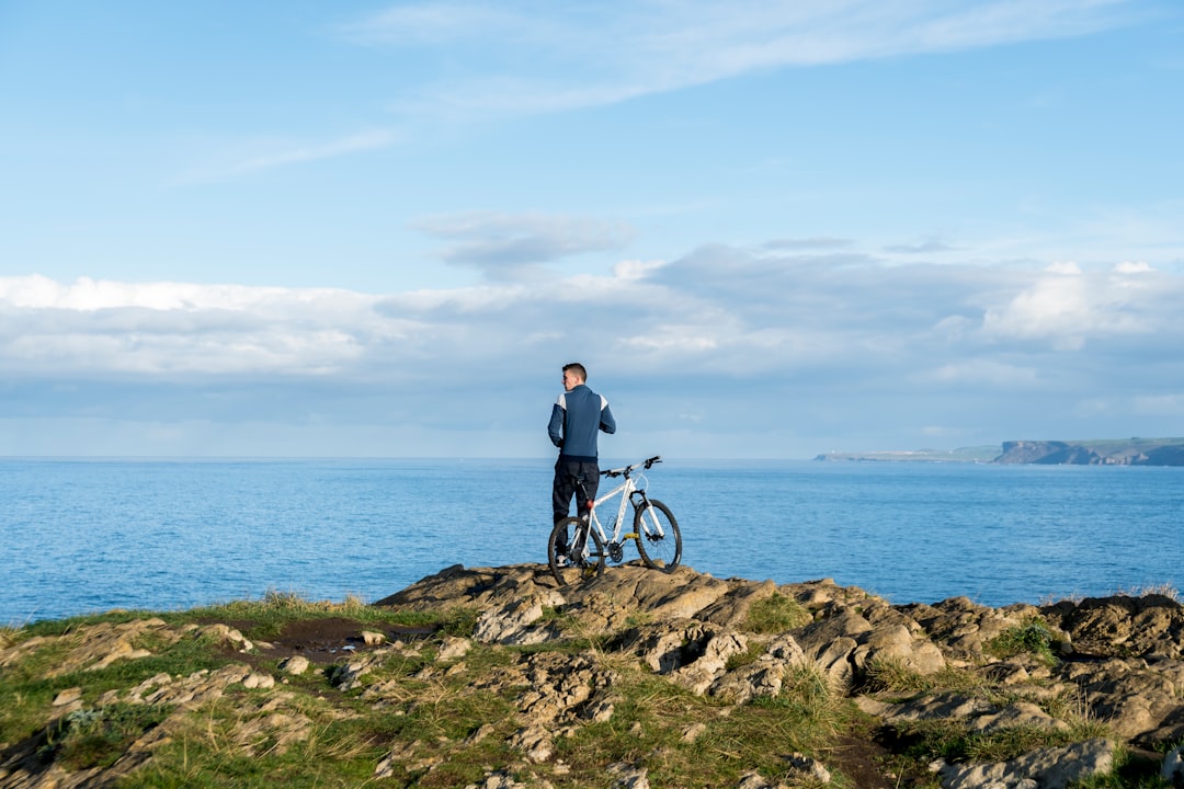 a man standing next to a bike on top of a hill