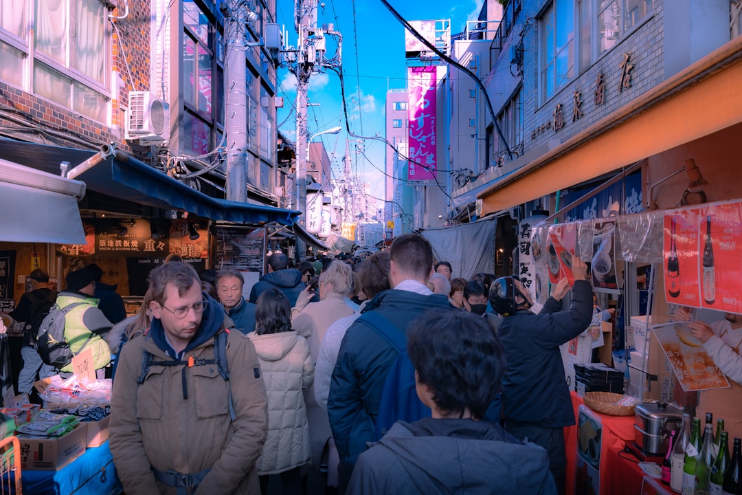 a crowd of people walking down a street next to tall buildings